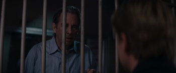Movie still from “A Christmas Mystery” (2022), directed by Alex Ranarivelo – A man standing behind bars in a jail cell; Close Up shot, Over the shoulder angle