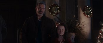 Movie still from “A Christmas Mystery” (2022), directed by Alex Ranarivelo – An older man and a young girl posing for a picture; Medium shot, Over the shoulder angle