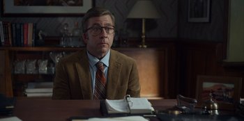 Movie still from “A Christmas Story Christmas” (2022), directed by Clay Kaytis – A man sitting at a desk in a suit and tie; Medium shot, Over the shoulder angle