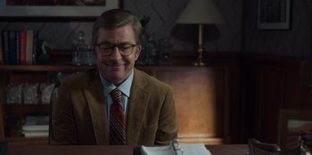 Movie still from “A Christmas Story Christmas” (2022), directed by Clay Kaytis – A man sitting at a table in front of a book; Medium shot, Over the shoulder angle