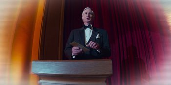 Movie still from “A Christmas Story Christmas” (2022), directed by Clay Kaytis – A man in a tuxedo standing in front of a podium; Medium shot, Low angle