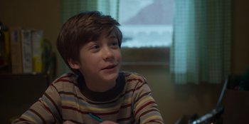 Movie still from “A Christmas Story Christmas” (2022), directed by Clay Kaytis – A young boy sitting in front of a window; Close Up shot, Over the shoulder angle