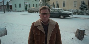 Movie still from “A Christmas Story Christmas” (2022), directed by Clay Kaytis – A man in a brown jacket standing in the snow; Medium shot, Low angle