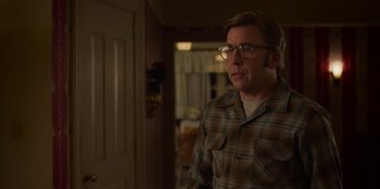 Movie still from “A Christmas Story Christmas” (2022), directed by Clay Kaytis – A man wearing glasses standing in front of a door; Medium shot, Over the shoulder angle