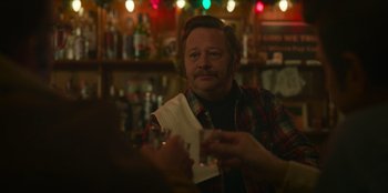 Movie still from “A Christmas Story Christmas” (2022), directed by Clay Kaytis – A man sitting at a table in front of a glass of wine; Close Up shot, Over the shoulder angle