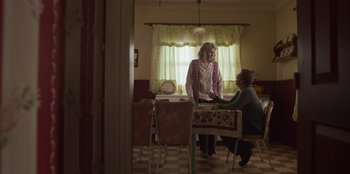 Movie still from “A Christmas Story Christmas” (2022), directed by Clay Kaytis – Two women are sitting at a table in a kitchen; Wide shot, Over the shoulder angle