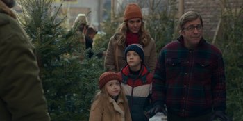 Movie still from “A Christmas Story Christmas” (2022), directed by Clay Kaytis – A woman and two children standing in front of christmas trees; Medium shot, Over the shoulder angle