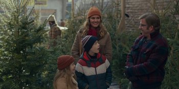 Movie still from “A Christmas Story Christmas” (2022), directed by Clay Kaytis – A woman and two children standing in front of trees; Medium shot, Over the shoulder angle