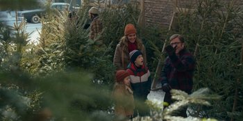 Movie still from “A Christmas Story Christmas” (2022), directed by Clay Kaytis – A group of people standing next to trees; Medium shot, Over the shoulder angle