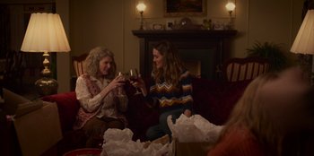 Movie still from “A Christmas Story Christmas” (2022), directed by Clay Kaytis – Two women sitting on a red couch drinking wine; Medium shot, Over the shoulder angle