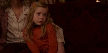 Movie still from “A Christmas Story Christmas” (2022), directed by Clay Kaytis – A little girl sitting on a couch with her arm around her mother; Close Up shot, High angle