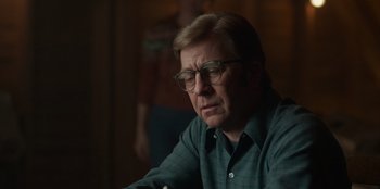 Movie still from “A Christmas Story Christmas” (2022), directed by Clay Kaytis – An older man wearing glasses sitting at a table; Close Up shot, Over the shoulder angle