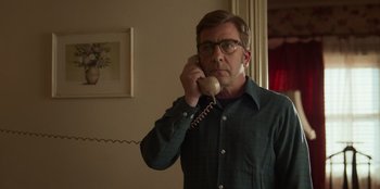 Movie still from “A Christmas Story Christmas” (2022), directed by Clay Kaytis – A man with glasses talking on a phone; Medium shot, Low angle