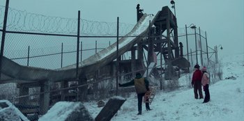 Movie still from “A Christmas Story Christmas” (2022), directed by Clay Kaytis – A man holding a skateboard next to a snow covered field; Extreme Wide shot, Low angle