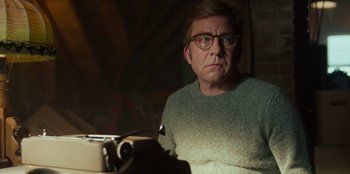 Movie still from “A Christmas Story Christmas” (2022), directed by Clay Kaytis – A man with glasses sitting in front of an old fashioned typewriter; Close Up shot, Low angle