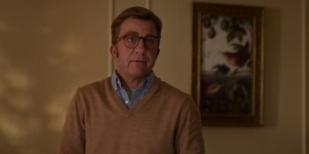 Movie still from “A Christmas Story Christmas” (2022), directed by Clay Kaytis – A man wearing glasses and a tan sweater looking to his left; Close Up shot, Low angle