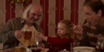 Movie still from “A Christmas Story Christmas” (2022), directed by Clay Kaytis – An older man and a little girl at a dinner table; Medium shot, Over the shoulder angle