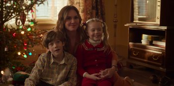 Movie still from “A Christmas Story Christmas” (2022), directed by Clay Kaytis – A woman and two children pose for a picture; Medium shot, Over the shoulder angle