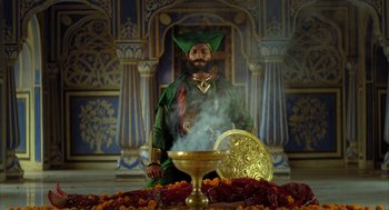 Movie still from “The Fall” (2006), directed by Tarsem Singh – A man dressed as a wizard in front of a pot of gold; Wide shot, High angle