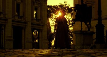 Movie still from “The Fall” (2006), directed by Tarsem Singh – A statue of a person standing in front of a building; Wide shot, Low angle