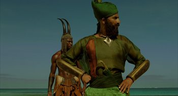 Movie still from “The Fall” (2006), directed by Tarsem Singh – A man in a turban is standing next to another man in a green shirt; Medium shot, Low angle