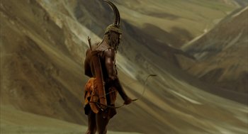 Movie still from “The Fall” (2006), directed by Tarsem Singh – A man with a bow and arrow standing in the desert; Medium shot, Low angle