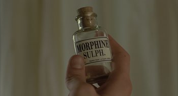Movie still from “The Fall” (2006), directed by Tarsem Singh – A person holding a bottle of morphine sulph; Extreme Close Up shot, Overhead angle