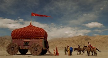 Movie still from “The Fall” (2006), directed by Tarsem Singh – A group of people standing next to a red tent on a dirt field; Extreme Wide shot, Low angle
