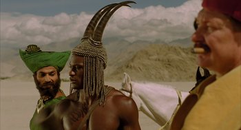 Movie still from “The Fall” (2006), directed by Tarsem Singh – A man with a horned headdress and a green hat; Medium shot, Low angle