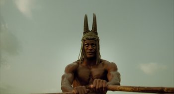Movie still from “The Fall” (2006), directed by Tarsem Singh – A man with a horned headdress is holding a wooden stick; Medium shot, Low angle