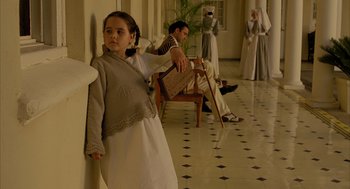 Movie still from “The Fall” (2006), directed by Tarsem Singh – A young girl standing in front of an older man and woman; Medium shot, Low angle