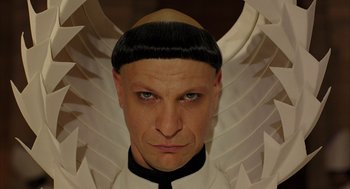 Movie still from “The Fall” (2006), directed by Tarsem Singh – A man with a black and white wig and a black tie; Close Up shot, Low angle