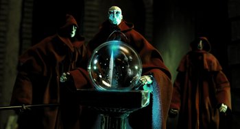 Movie still from “The Fall” (2006), directed by Tarsem Singh – Two people in robes and hoods stand in front of a crystal ball; Medium shot, Low angle