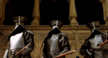 Movie still from “The Fall” (2006), directed by Tarsem Singh – Two men in medieval armor holding guns in front of a stone wall; Medium shot, Low angle