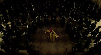 Movie still from “The Fall” (2006), directed by Tarsem Singh – A group of people standing in a circle with a violin; Extreme Wide shot, High angle