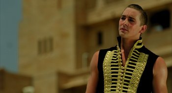 Movie still from “The Fall” (2006), directed by Tarsem Singh – A man in a black shirt is holding a gun belt; Close Up shot, Low angle