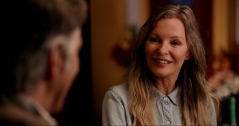 Movie still from “A Cowgirl's Song” (2022), directed by Timothy Armstrong – A woman smiles at the camera while talking to a man; Close Up shot, Over the shoulder angle
