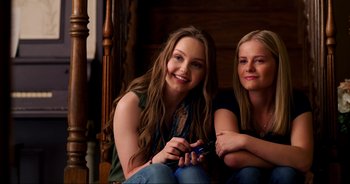 Movie still from “A Cowgirl's Song” (2022), directed by Timothy Armstrong – Two young women sitting next to each other; Close Up shot, High angle