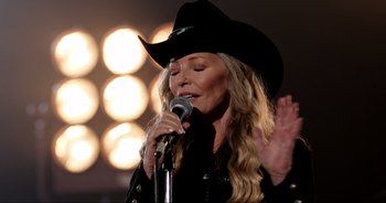 Movie still from “A Cowgirl's Song” (2022), directed by Timothy Armstrong – A woman wearing a cowboy hat is singing into a microphone; Close Up shot, Low angle