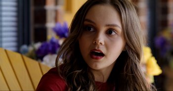 Movie still from “A Cowgirl's Song” (2022), directed by Timothy Armstrong – A young woman with long hair and a surprised look; Close Up shot, Over the shoulder angle