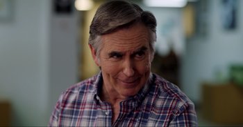 Movie still from “A Cowgirl's Song” (2022), directed by Timothy Armstrong – An older man in a checkered button down shirt; Close Up shot, Over the shoulder angle