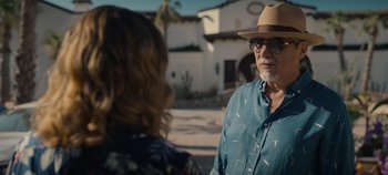 Movie still from “A Deadly Invitation” (2023), directed by J.M Cravioto – An older man wearing a hat talking to an older woman; Close Up shot, Over the shoulder angle