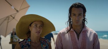 Movie still from “A Deadly Invitation” (2023), directed by J.M Cravioto – A man and a woman standing next to each other on the beach; Close Up shot, Low angle