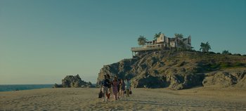Movie still from “A Deadly Invitation” (2023), directed by J.M Cravioto – A group of people walking on the beach; Extreme Wide shot, Low angle