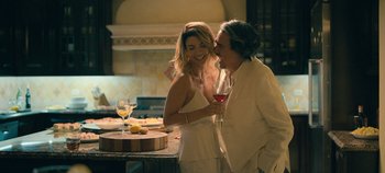 Movie still from “A Deadly Invitation” (2023), directed by J.M Cravioto – A man and a woman standing next to each other holding a wine glass; Medium shot, Low angle