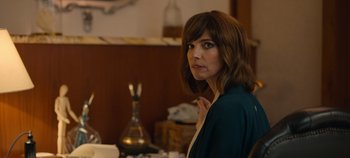 Movie still from “A Deadly Invitation” (2023), directed by J.M Cravioto – A woman sitting at a table in front of a vase; Close Up shot, Over the shoulder angle