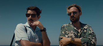 Movie still from “A Deadly Invitation” (2023), directed by J.M Cravioto – Two men standing next to each other on the beach; Close Up shot, Low angle