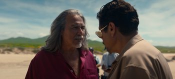 Movie still from “A Deadly Invitation” (2023), directed by J.M Cravioto – A man with long grey hair talking to another man; Close Up shot, Over the shoulder angle