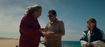 Movie still from “A Deadly Invitation” (2023), directed by J.M Cravioto – A man and a woman standing next to each other on the beach; Medium shot, Over the shoulder angle