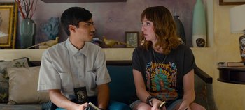 Movie still from “A Deadly Invitation” (2023), directed by J.M Cravioto – A man and a woman sitting next to each other on a couch; Medium shot, Over the shoulder angle